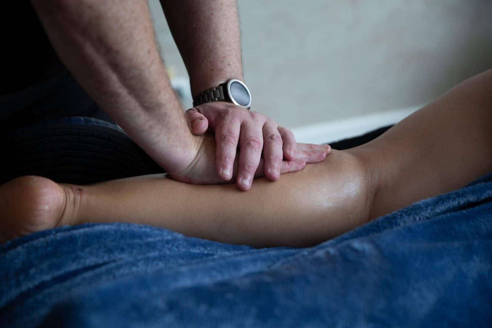 Sports massage delivered with controlled pressure and consent